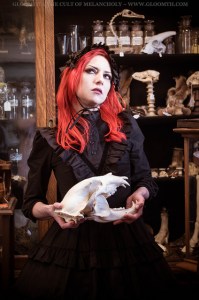 red hair gothic model holding a bobcat skull in an antique shop