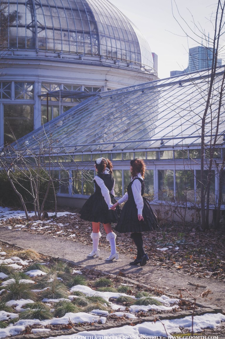 two gothic lolitas walking towards a greenhouse