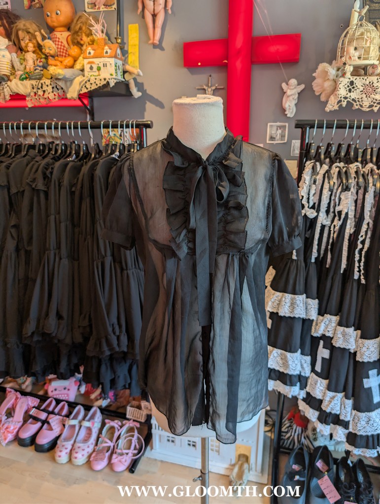 sheer black gothic blouse on display at doll funeral shop in toronto