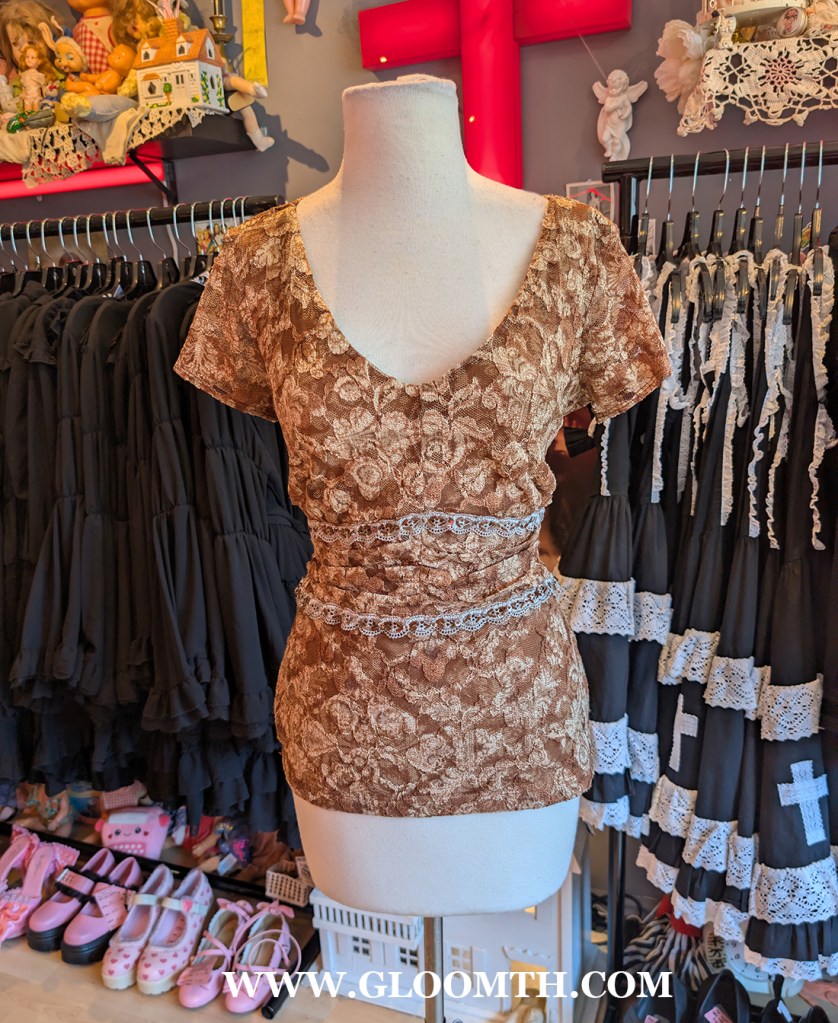 brown lace blouse on display at doll funeral shop in toronto