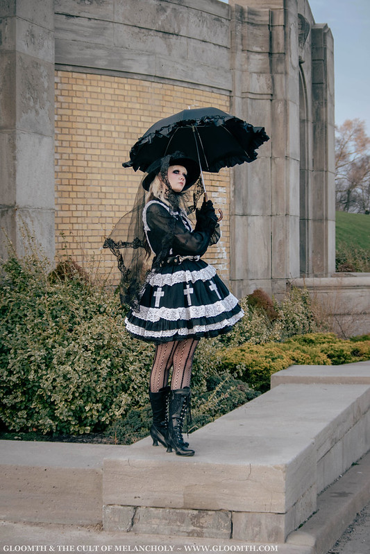 victorian gothic dress worn by a model holding a goth parasol in front of an antique building